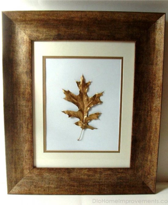 Dried leaf covered with gold paint in a frame