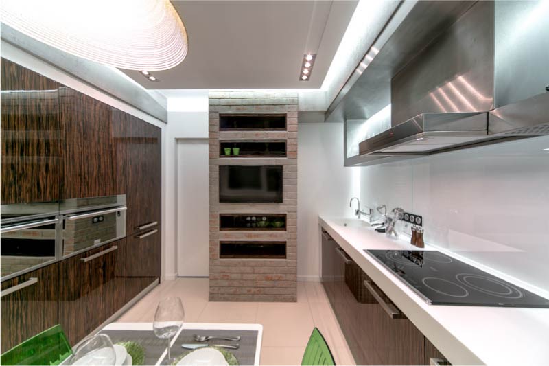 Virtuvė su lygiagrečiu išdėstymu ir stalu centre.